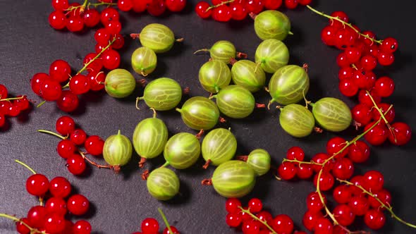 Delicious Red Cranberry and Juicy Green Gooseberry on a Black Stone Table