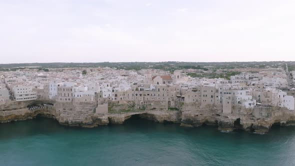 Static aerial footage of town that sits atop the cliffs above the sea in Polignano a Mare, Italy.