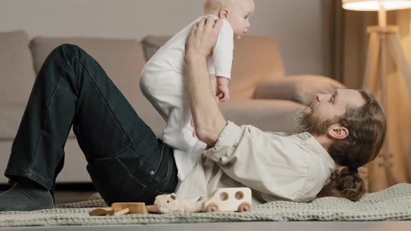 Caucasian Family at Home Adult Bearded Father Dad Lying on Floor with Little Daughter Son Baby