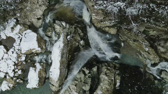 Waterfall Flowing From White Rocks Into a Lake in the Forest