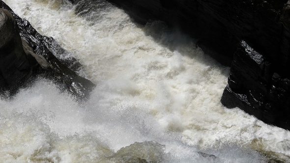 Waterfall hitting and splash on the surface of hard rocks,