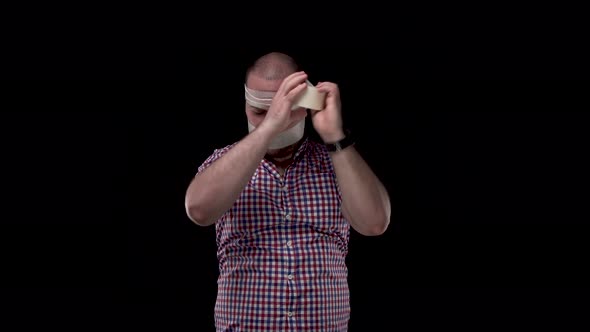 Guy in a Checkered Red-blue Shirt on Black Isolate Background Wraps His Head with Tape. Protest, I