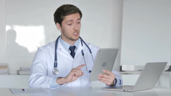 Young Doctor Talking with Patient via Video Chat on Tablet