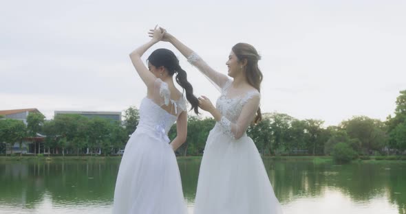 Happy Asian Lesbian Married Couple Dancing In The Park.