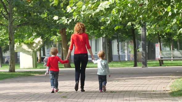 Family on a Walk in Summer. Child with Mother Together. Slow Motion