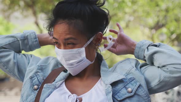 Mixed race woman fixing medical coronavirus mask