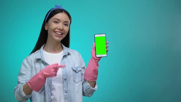 Girl in Gloves Pointing Finger at Smartphone With Green Screen, Cleaning Service