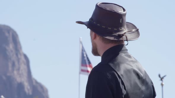 Cowboy looking at the camera in front of american flag