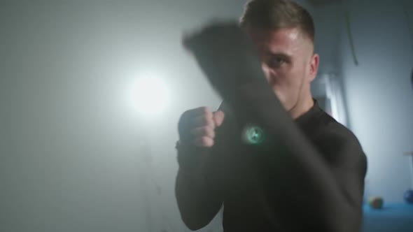 Man Fighter Trains His Punches and Defense in the Boxing Gym a Man Boxer Trains in Front of a Mirror