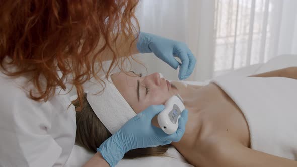 Beautician Using Professional Equipment During Ultrasonic Skin Care Treatment Face Cleaning