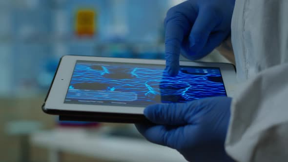 Close Up of Chemist Doctor Working on Tablet with DNA Scan Image