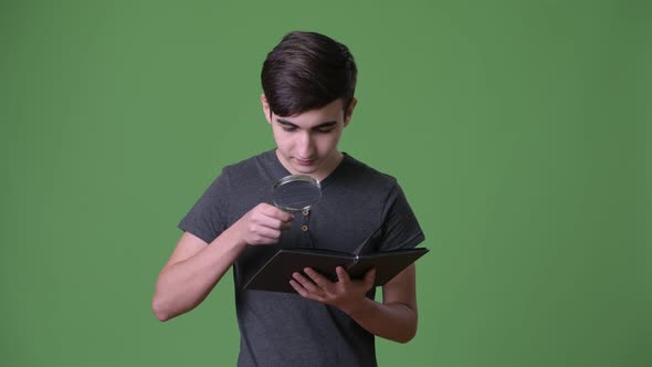 Young Handsome Iranian Teenage Boy Against Green Background