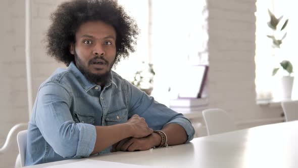 Shocked Creative African Man Wondering and Working on Laptop