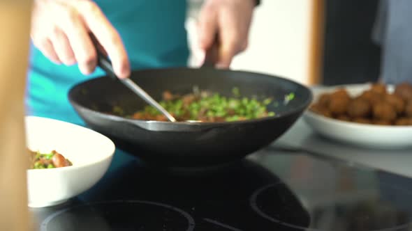 Spooning cooked peas into serving bowl