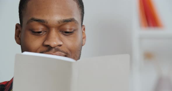 Portrait of African American Guy Looking at Book Pretending To Read Studying Business Literature