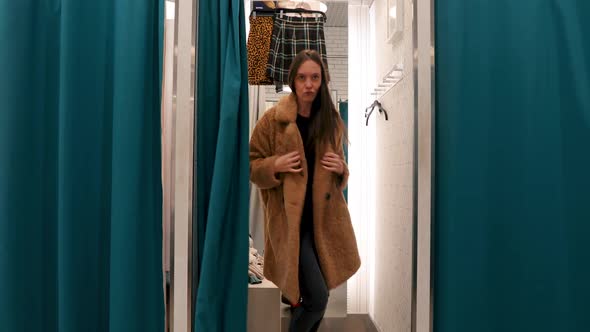 Woman Dancing in a Dressing Room of a Store in Coat