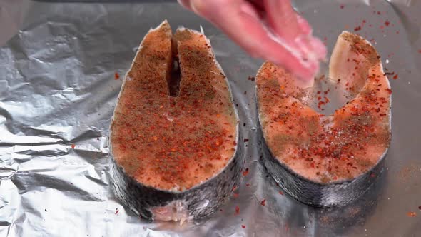 Chef adding spices on raw salmon steak before baking. Raw salmon Fillet or red fish steak