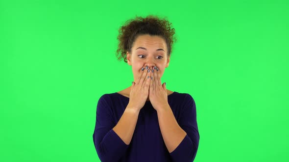 Portrait of Curly Woman Disappointed Looking in Camera Biting Her Lips. Green Screen