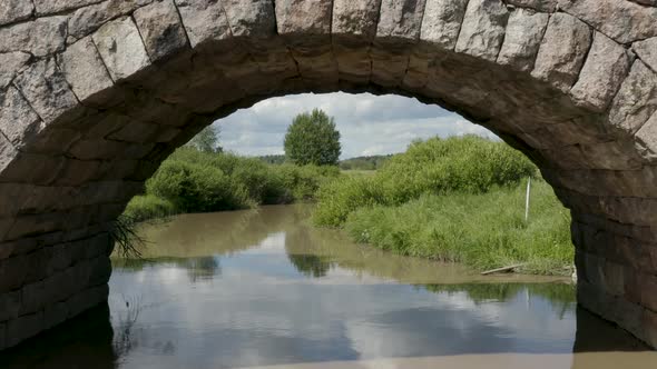 Slow aerial fly through of an old stone bridge in Finland near Kerava.