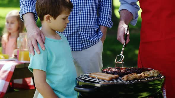 Multi-generation family preparing food on barbecue