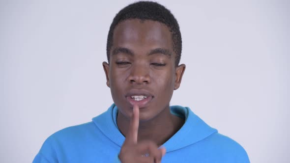 Face of Young Happy African Man with Finger on Lips