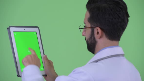 Closeup Rear View of Happy Young Bearded Persian Man Doctor Using Digital Tablet