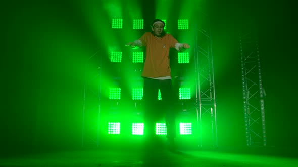 Professional Young Hip-hop Dancer, Dancing in Dark Studio in the Green and Yellow Fog. Hip Hop