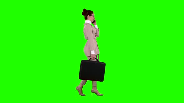 Business Lady with Cases in Hands Speaks on the Phone. Green Screen. Side View