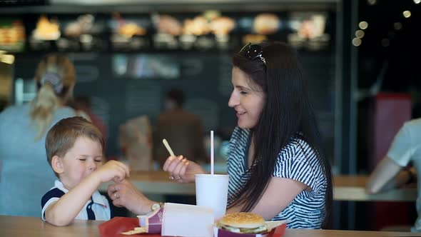 Pretty Young Mother and Child Eating Fast Food