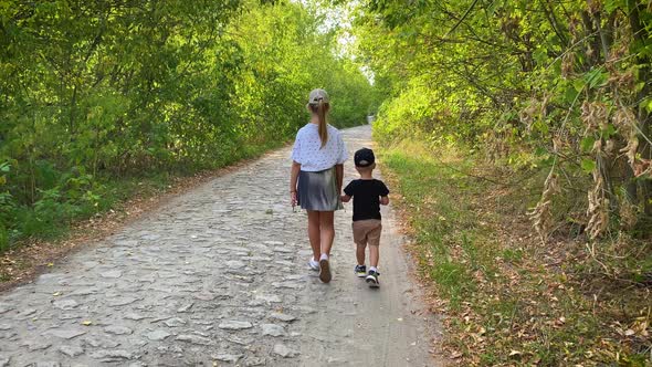 Old Sister and Little Brother Holding Hands on Walking in Forest.