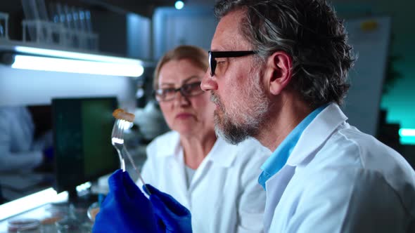 Middle Aged Colleagues Tasting Chicken Cell Meat