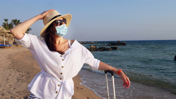 Woman in Protective Mask, Summer Clothes, Sunglasses and Sun Hat, Enjoying Warm Sunbeams, on Sea
