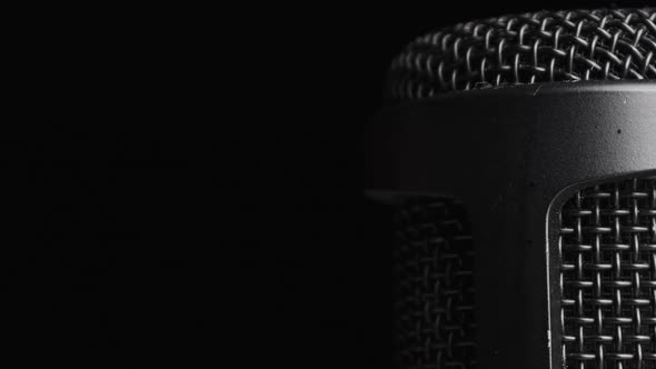 Studio Condenser Microphone Rotates on Black Background with Place for Text