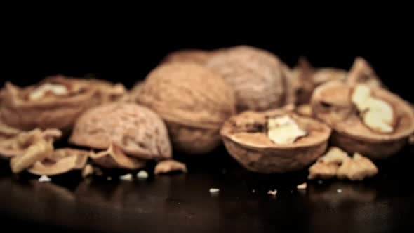 Whole Walnut Rolls in Slow Motion Against a Background of Pile of Nuts in a Loop