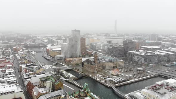 Drone cinematic circling, snowing Malmö. Clarion hotel, turning torso, Malmo university