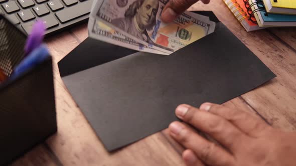 Person Hand Putting Cash in a Envelope