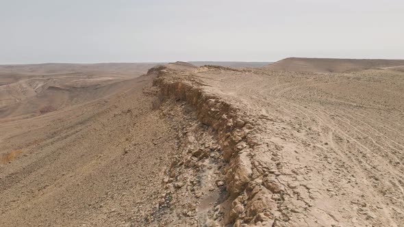 Aerial flight over Israeli desert mountain formation at Ramon crater valley.