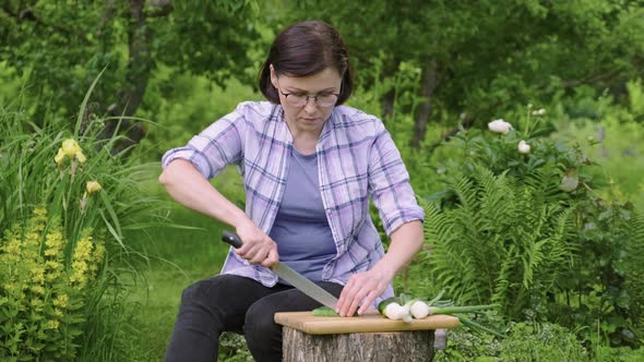 Middle Aged Woman Making Vegetable Salad in Garden Outdoor