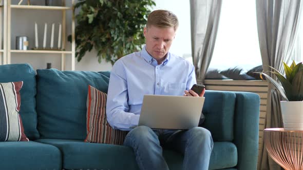 Middle Aged Man Using Smartphone at Workplace