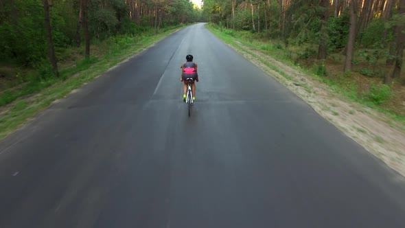 Woman Is Cycling on Country Road During Triathlon Training