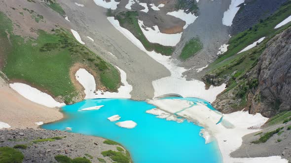 Turquoise Glacial Lake in Big Snowy Mountains. Aerial View 