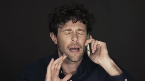 Slow motion shot of man having stressful phone call on cell phone