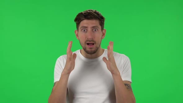 Portrait of Confident Guy Is Looking at Camera with Anticipation, Then Very Upset. Green Screen