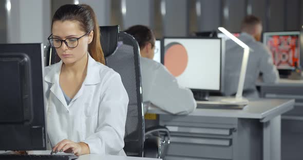 Engineers in White Coats Using Computers in Office