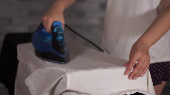 Woman Ironing Clothes on Ironing Board Closeup