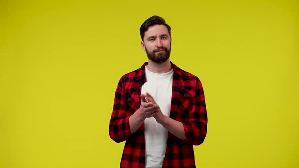 Portrait of a Man Applauding with His Hands on Yellow Studio Background