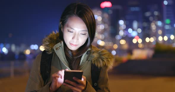 Woman using smart phone at night