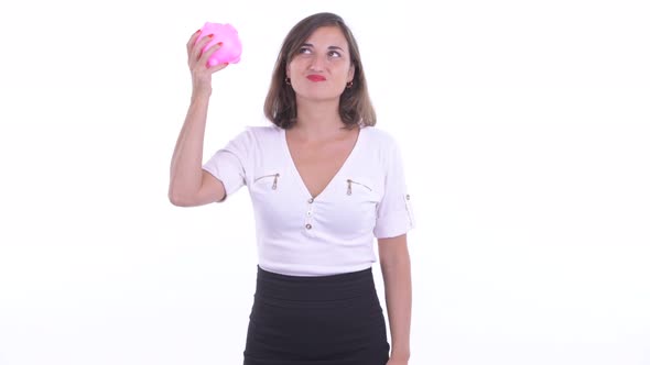 Stressed Businesswoman Holding Piggy Bank and Giving Thumbs Down