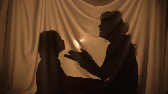 Silhouettes of Woman and Boy Telling Stories Using Shadow Play Talking and Communication