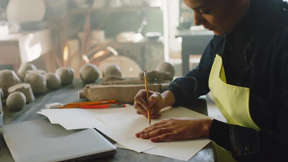 Woman Is Making Sketches of Pots